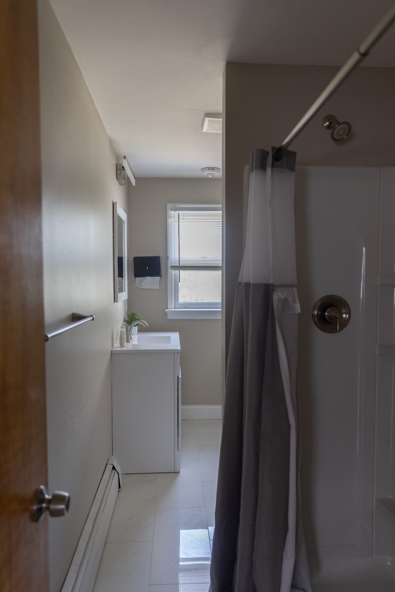 Compact bathroom with white vanity and walk-in shower