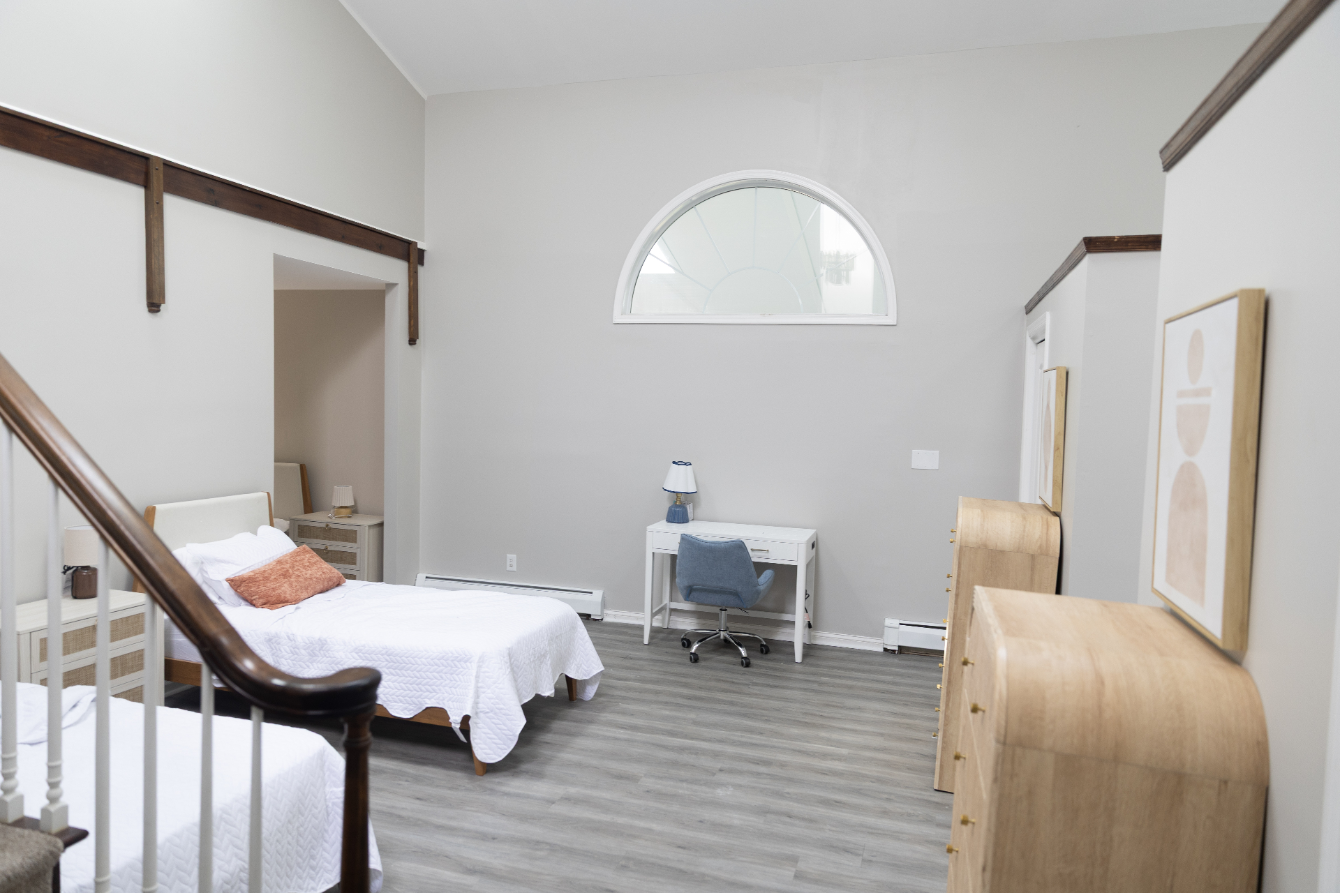 Bedroom with twin bed, desk, and arched window