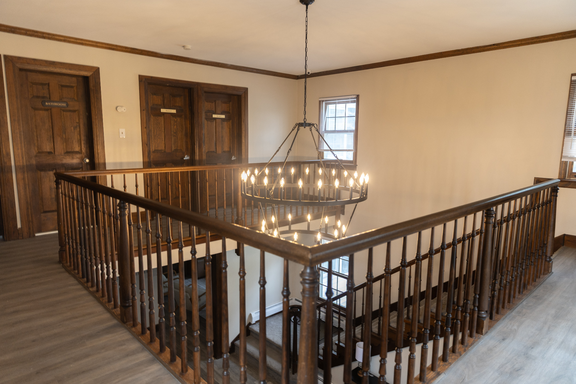 Upstairs landing with black wagon-wheel chandelier