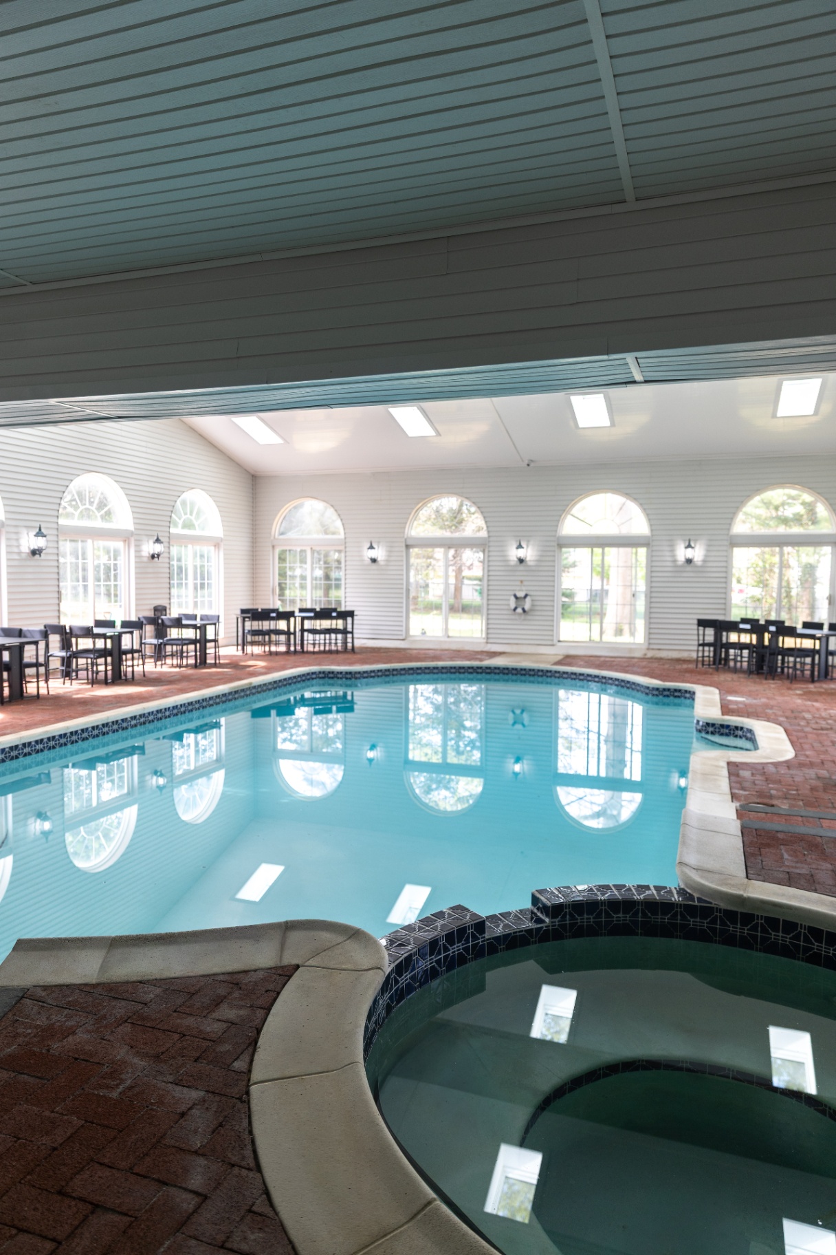 Indoor pool area featuring a hot tub
